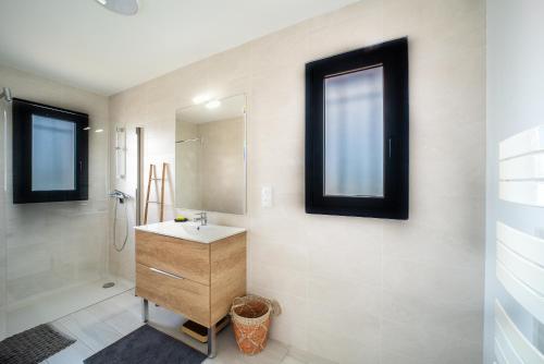 a bathroom with a sink and a mirror at Maison Le Boulou - Grand jardin piscine privée in Le Boulou