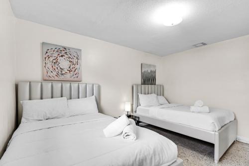 2 Betten in einem Zimmer mit weißen Wänden in der Unterkunft Authentic Two Bedroom Unit / Parking in Miami