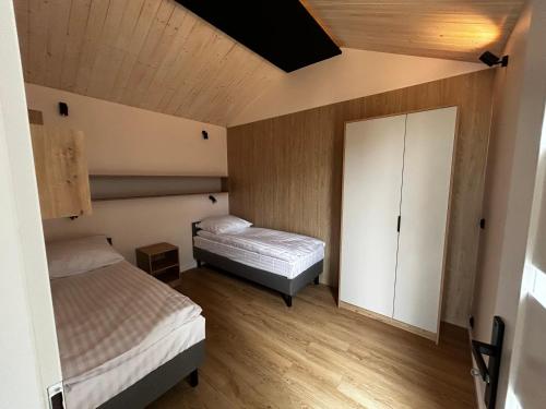 Dormitorio pequeño con 2 camas y armario en Pensjonat Żurawi Kąt, en Górkło
