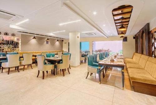 Green Hotel - Behind Parmarth Niketan في ريشيكيش: مطعم فيه كنب وطاولات وكراسي