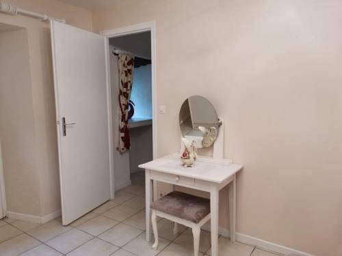 une coiffeuse blanche avec un miroir et une chaise dans l'établissement Gite Regal, à Suaux