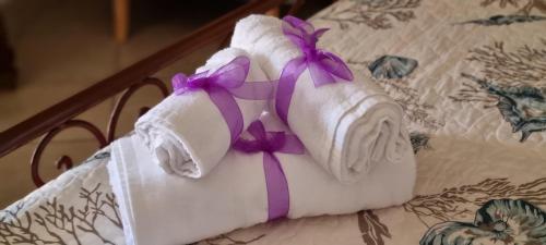 una pila di asciugamani con fiocchi viola su un tavolo di CASA ORCHIDEA a Portoferraio