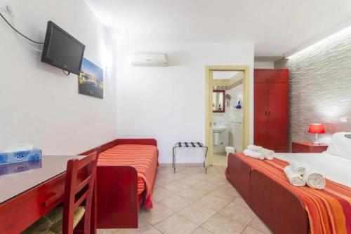 a room with two beds and a tv on the wall at Masseria Un Posto al Sole in Otranto