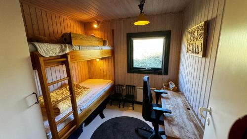 een kleine kamer met stapelbedden en een bureau bij Veludstyret sommerhus i unik natur 350 m fra lækker badestrand - helårsbolig in Saltum