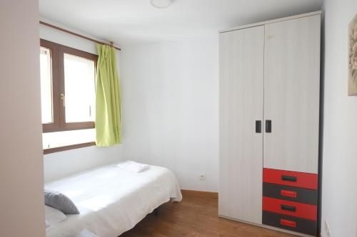 a white bedroom with a bed and a cabinet at Entre Castillo y Catedral VuT 09587 in Burgos