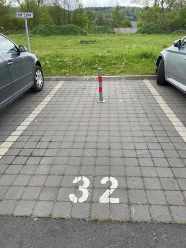 two cars parked in a parking lot with a pole at SPA Apartment Moser in Karlovy Vary