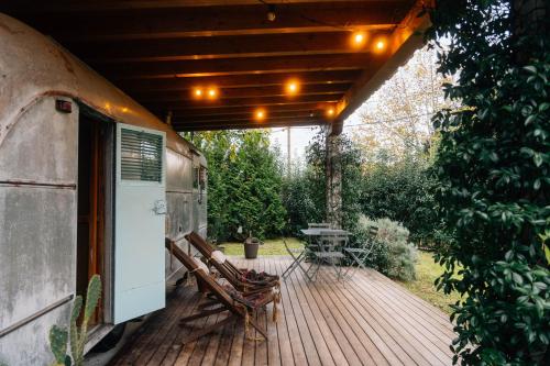 an outdoor deck with two chairs and a grill at The Caravan in Hoz de Anero
