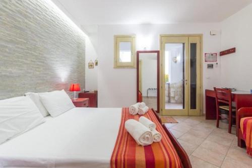 a bedroom with a white bed with towels on it at Masseria Un Posto al Sole in Otranto