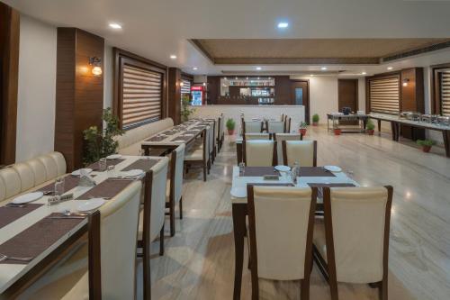 um restaurante com mesas e cadeiras longas e um bar em Spree Hotel Agra - Walking Distance to Tajmahal em Agra