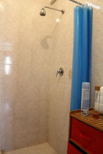 a shower with a blue shower curtain in a bathroom at SaMi house - fronte mare del Salento in San Foca