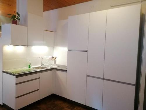 a white kitchen with a sink and white cabinets at Ferienwohnung Claudia in San Bernardino
