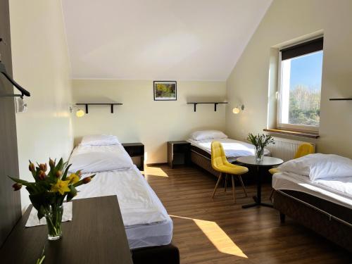 pokój hotelowy z 2 łóżkami i stołem w obiekcie Willa Ogrodnika w mieście Błażowa