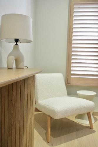 a white lamp sitting on a desk next to a chair at Nova Nocte in Tongeren