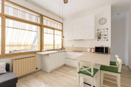 a kitchen with white cabinets and a table with a microwave at Cute Flat near the Beach with Parking in Viareggio