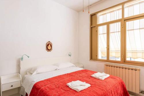 a bedroom with a bed with two towels on it at Cute Flat near the Beach with Parking in Viareggio