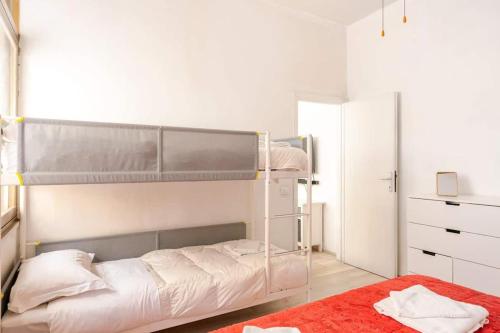 a bedroom with a bunk bed with a red rug at Cute Flat near the Beach with Parking in Viareggio