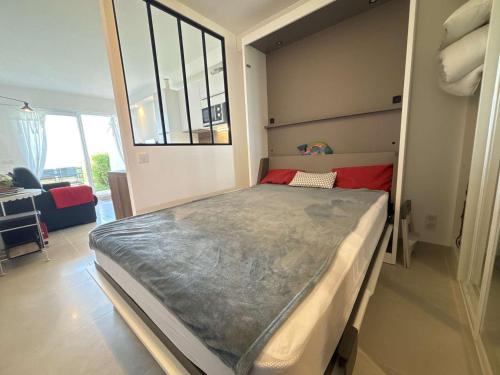 une chambre avec un grand lit dans une pièce dans l'établissement Studio en bord de mer à Royan, parking, TV, tout équipé - FR-1-494-67, à Royan