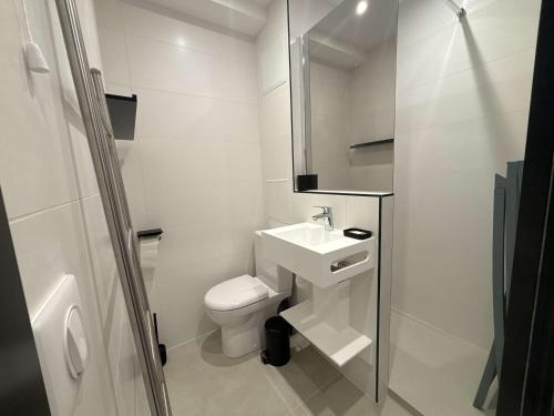 une salle de bain blanche avec un lavabo et des toilettes dans l'établissement Studio en bord de mer à Royan, parking, TV, tout équipé - FR-1-494-67, à Royan