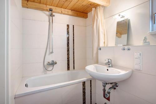 a bathroom with a sink and a bath tub at Göhrli Ferienhaus Nr 25 in Göhren