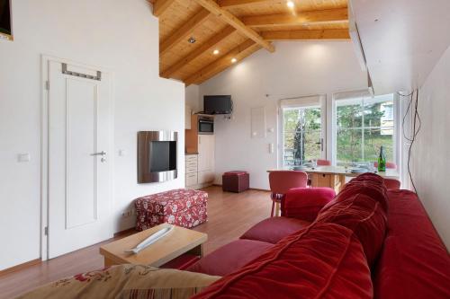 a living room with a red couch and a table at Göhrli Ferienhaus Nr 25 in Göhren