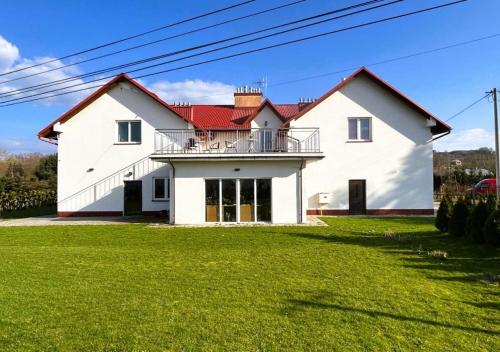 una gran casa blanca con un patio verde en Willa Ogrodnika en Błażowa