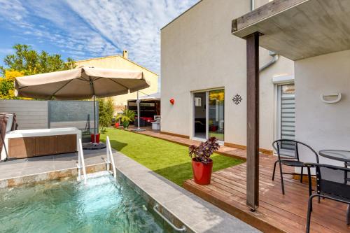 une cour avec une piscine et un parasol dans l'établissement Villa 6 personnes avec piscine, à Pérols