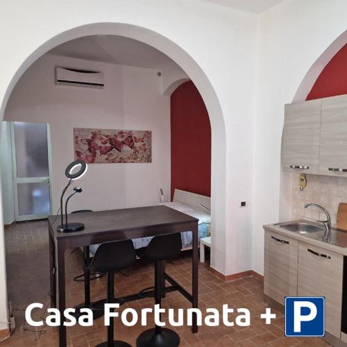 リヴォルノにあるCasa Fortunata con parcheggioのキッチン(ランプ付きのテーブル付)