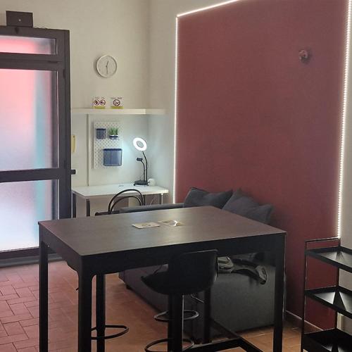 a room with a table and a desk with a chair at Casa Fortunata con parcheggio in Livorno