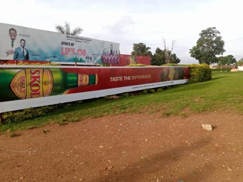 a train with advertisements on the side of a wall at AIM Kanombe INN MOTEL in Kigali