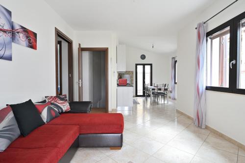 ein Wohnzimmer mit einem roten Sofa und einer Küche in der Unterkunft Casa Bari Sardo per più famiglie in Bari Sardo