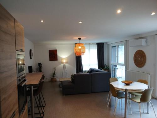 ein Wohnzimmer mit einem Sofa und einem Tisch in der Unterkunft Appartement Confort Miribel 80m2 in Miribel