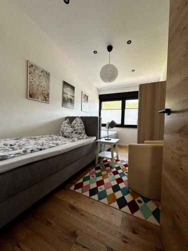 a bedroom with a bed and a table and a rug at Ferienwohnungen Heimatliebe in Ernst