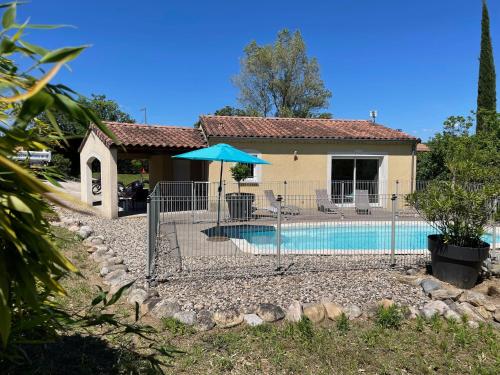 a house with a swimming pool with a blue umbrella at Villa MIMOSA in Sampzon