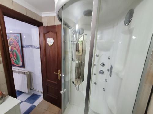 uma casa de banho com um chuveiro e uma porta de vidro em Precioso bajo con piscina en Soto de la marina em Soto de la Marina