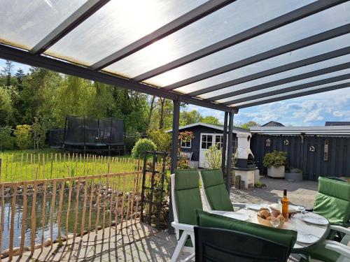 a pergola on a patio with a table and chairs at Ferienhaus Mühlchen 25585 in Weener