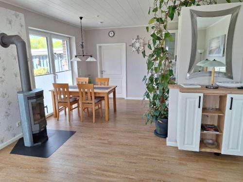 a living room with a table and a fireplace at Ferienhaus Mühlchen 25585 in Weener