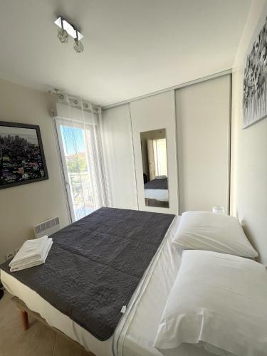 une chambre avec deux lits et une grande fenêtre dans l'établissement Deux pièces climatisé plage à pied et garage, à Antibes