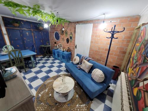 uma sala de estar com um sofá azul e uma mesa em Precioso bajo con piscina en Soto de la marina em Soto de la Marina