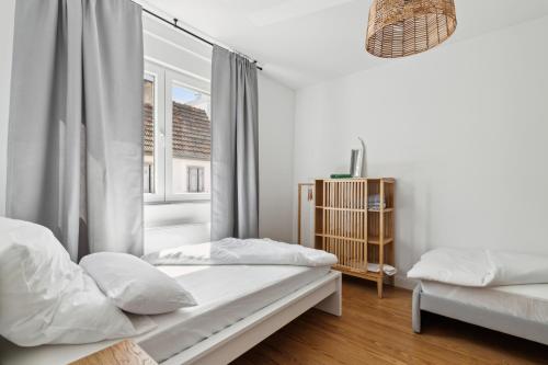 a white bedroom with two beds and a window at modern living - BASF - MA - PFALZ - 1 Gym 2 Working Spaces in Ludwigshafen am Rhein