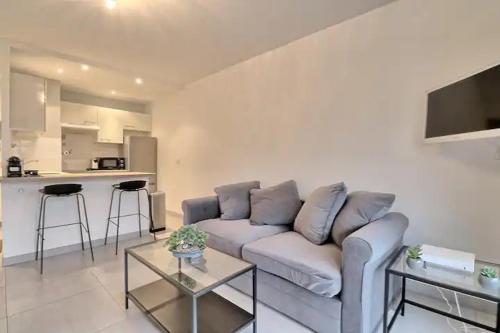 un salon avec un canapé et une cuisine dans l'établissement Appartement proche des Plages et du Palais, à Cannes