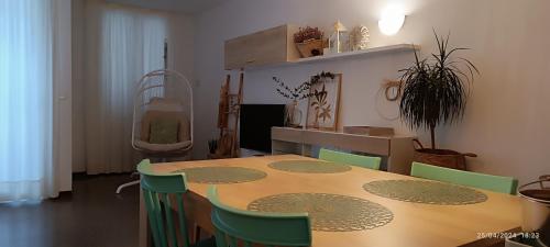 a dining room with a table and green chairs at La Yeye in Port de la Selva