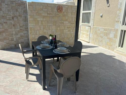 a black table and chairs on a patio at Villa Tellina Mare Luna in Granelli