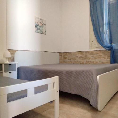 a bedroom with two beds and a blue curtain at Villa Tellina Mare Luna in Granelli
