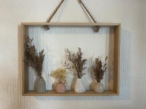 a shelf with three vases with flowers in them at Manchester Stay Hotel - Free Parking in Manchester