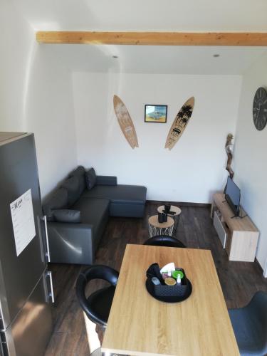 un salon avec une table et un canapé dans l'établissement Petite maison neuve proche du lac, à Parentis-en-Born