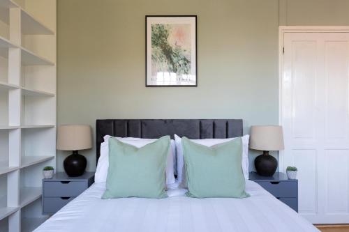 The Morden Hall Collection في Morden: غرفة نوم بسرير ابيض مع مخدات زرقاء