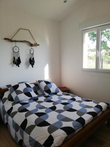 - une chambre avec une couette en noir et blanc sur un lit dans l'établissement Petite maison neuve proche du lac, à Parentis-en-Born