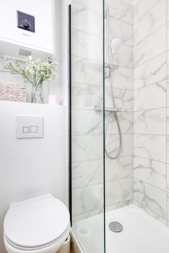 une salle de bain blanche avec douche et toilettes dans l'établissement JO 2024 - Face au métro 13 - 26 m2 refait à neuf, à Saint-Ouen