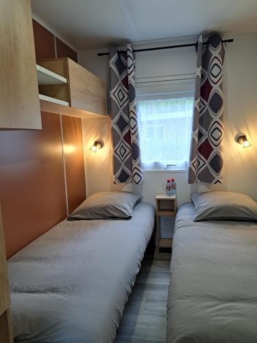 deux lits dans une petite pièce avec une fenêtre dans l'établissement Au 7cent14, à Marcilly-sur-Eure