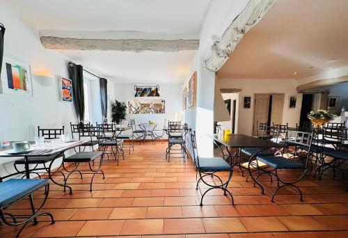 une salle à manger avec tables et chaises dans un bâtiment dans l'établissement Auberge d'Anais, à Entrechaux